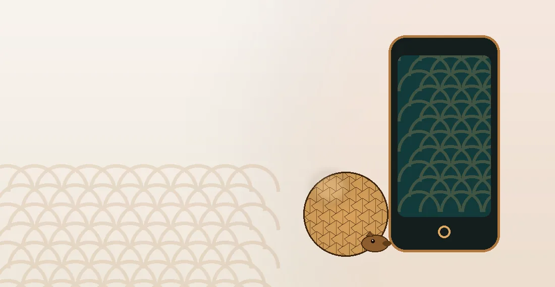Opgerolde pangolin naast een telefoon